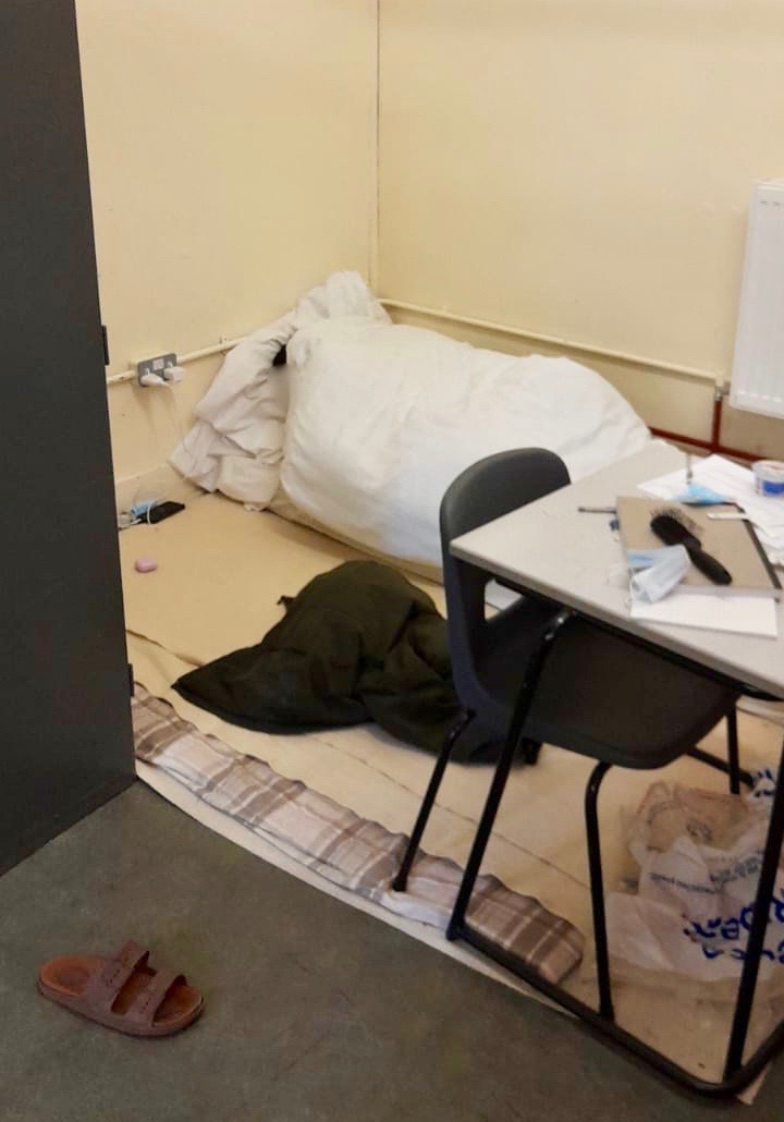 Image shows a man under a duvet on the floor
