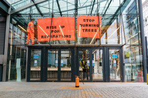 London, UK. 27 April 2022. Protestor from Axe Drax spray paint to the outside of the entrance to BEIS (Department for Business, Energy and Industrial strategy)